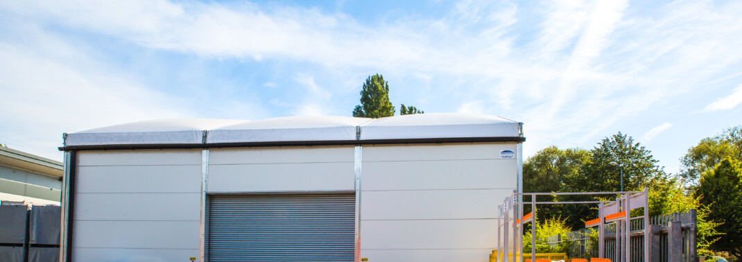 White-temporary-building-with-grey-roller-shutter-door